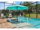 Backyard pool with sun shelf, lounge chair, umbrella, and relaxing water feature at 13819 American Prairie Pl, Bradenton, FL 34211