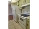 Bright kitchen featuring white appliances and vintage green cabinets at 1509 Overbrook Rd, Englewood, FL 34223