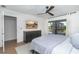 Bedroom featuring neutral colors, wood floors, ceiling fan, television, and lanai access at 16 Leeward Dr, Placida, FL 33946
