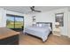 Bright bedroom with wood floors, ceiling fan, and slider access to lanai with golf course views at 16 Leeward Dr, Placida, FL 33946