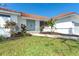 Charming single-story home featuring a well-maintained lawn, garden beds, and a welcoming double-door entry at 16 Leeward Dr, Placida, FL 33946