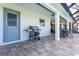 Covered patio area featuring grill, table, chairs, and pavers at 16 Leeward Dr, Placida, FL 33946