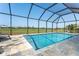Screened-in pool with view of golf course, blue tile, and stone trim at 16 Leeward Dr, Placida, FL 33946