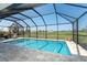 Enclosed pool area with blue tile and view of the golf course at 16 Leeward Dr, Placida, FL 33946