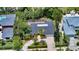 Aerial view of a home with a large driveway, mature landscaping, and a screened in pool at 1610 S Orange Ave, Sarasota, FL 34239