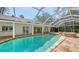 Outdoor pool and spa surrounded by stone tiles in a screened enclosure at 1610 S Orange Ave, Sarasota, FL 34239