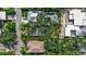 Aerial view featuring a house with a swimming pool nestled between lush greenery and neighboring residences at 1677 Hyde Park St, Sarasota, FL 34239