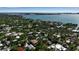 Aerial shot showcasing a neighborhood's lush tree cover with houses nestled amongst foliage with waterways in the background at 1677 Hyde Park St, Sarasota, FL 34239
