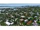 Expansive aerial view of a lush residential neighborhood with mature trees and stunning waterfront views, plus nearby city skyline at 1677 Hyde Park St, Sarasota, FL 34239
