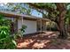 Backyard patio with brick flooring and large windows overlooking lush vegetation and mature trees at 1677 Hyde Park St, Sarasota, FL 34239