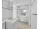 Compact bathroom featuring a tiled sink and mirror, complemented by a spacious open shelf area at 1677 Hyde Park St, Sarasota, FL 34239