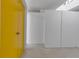 Minimalist entryway with gray concrete floor and yellow closet doors provides ample storage space at 1677 Hyde Park St, Sarasota, FL 34239
