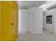 Minimalist entryway with gray concrete floors and bright yellow doors leading to kitchen with modern appliances at 1677 Hyde Park St, Sarasota, FL 34239