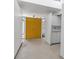 Minimalist entryway with gray concrete floor, yellow doors, white walls and cabinets, and natural light at 1677 Hyde Park St, Sarasota, FL 34239