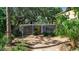 Inviting single-story home featuring a minimalist design, wooden siding, yellow front door, and xeriscaped front yard at 1677 Hyde Park St, Sarasota, FL 34239