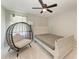 Bright bedroom featuring neutral paint, carpet floors, a ceiling fan, and an accent chair by the window at 1721 Palm Warbler Ln, Ruskin, FL 33570
