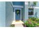 Inviting front door adorned with a wreath and surrounded by colorful flowers and greenery at 1721 Palm Warbler Ln, Ruskin, FL 33570