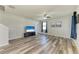 Living room featuring gray wood floors, a ceiling fan, and a large TV at 1721 Palm Warbler Ln, Ruskin, FL 33570