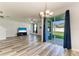 Bright living room featuring gray wood floors and a sliding glass door to the patio at 1721 Palm Warbler Ln, Ruskin, FL 33570