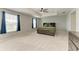 Spacious main bedroom featuring neutral walls, carpeted floors, tray ceiling with a fan, and abundant natural light at 1721 Palm Warbler Ln, Ruskin, FL 33570