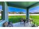 Covered patio with outdoor seating overlooking a lush, green backyard and white fence at 1721 Palm Warbler Ln, Ruskin, FL 33570