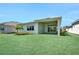 Beautiful backyard featuring a green lawn, tropical plants, and an outdoor patio at 17723 Palmiste Dr, Bradenton, FL 34202
