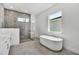 Bright, spa-like bathroom features a walk-in shower and freestanding tub next to a large window at 17723 Palmiste Dr, Bradenton, FL 34202