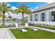 A recreational lawn with cornhole, Adirondack chairs, palms and a pool in the background at 17723 Palmiste Dr, Bradenton, FL 34202