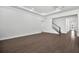 Open living area with hardwood floors, with staircase and a modern kitchen in the background at 17723 Palmiste Dr, Bradenton, FL 34202