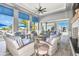 An open lounge area with woven chairs, striped cushions, a fireplace, TV and black and white patterned flooring at 17723 Palmiste Dr, Bradenton, FL 34202