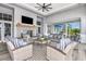 An open lounge area with woven chairs, striped cushions, a fireplace, TV and black and white patterned flooring at 17723 Palmiste Dr, Bradenton, FL 34202