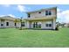 Home backyard featuring green grass, an extended covered patio, and lake views at 17911 Palmiste Dr, Bradenton, FL 34202