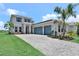 Elegant home with a paver driveway, lush landscaping, and a spacious three-car garage at 17911 Palmiste Dr, Bradenton, FL 34202
