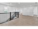 Open loft area with wood flooring, black railing, and plenty of natural light from the windows at 17911 Palmiste Dr, Bradenton, FL 34202