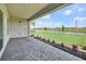 Covered brick patio looking out to a large green lawn and beautiful lake at 17911 Palmiste Dr, Bradenton, FL 34202
