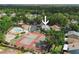 A high aerial view of a residential community showcasing trees, a pool, and tennis courts at 1869 Springbush Ln, Clearwater, FL 33763