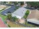 An aerial shot displays the backyard patio and the surrounding landscape with tennis courts at 1869 Springbush Ln, Clearwater, FL 33763