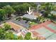Aerial view of property featuring tennis courts, parking, lush greenery and pool with cabana at 1869 Springbush Ln, Clearwater, FL 33763