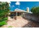 View of home's backyard featuring a brick-paved area and mature greenery at 1869 Springbush Ln, Clearwater, FL 33763