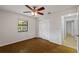 Well-lit bedroom with wood floors, fan, closet, and access to other areas of the home at 1869 Springbush Ln, Clearwater, FL 33763