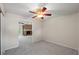 Spacious carpeted room with fan and an open doorway leading into a living area with a fireplace at 1869 Springbush Ln, Clearwater, FL 33763