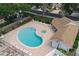 A serene community pool area is highlighted by the ample seating, spa, and lush landscaping at 1869 Springbush Ln, Clearwater, FL 33763