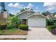 Charming one-story home with a well-manicured lawn, lush landscaping, and a two-car garage at 1869 Springbush Ln, Clearwater, FL 33763