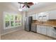 Sunlit eat in kitchen with tile flooring, stainless steel appliances, and white cabinets at 1869 Springbush Ln, Clearwater, FL 33763