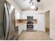 Bright kitchen featuring stainless appliances, white cabinetry, and tile flooring at 1869 Springbush Ln, Clearwater, FL 33763
