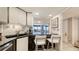 Kitchen features white cabinets, granite countertops, and bar seating with ocean view at 2045 Gulf Of Mexico Dr # M1-514, Longboat Key, FL 34228