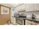 Close up of kitchen with white cabinetry, granite countertop, and stainless appliances at 2045 Gulf Of Mexico Dr # M1-514, Longboat Key, FL 34228