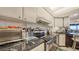 Close up of kitchen with white cabinetry, granite countertop, and stainless appliances at 2045 Gulf Of Mexico Dr # M1-514, Longboat Key, FL 34228
