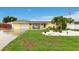 Inviting single-story home featuring a well-manicured lawn and solar panels at 212 66Th Avenue W Dr, Bradenton, FL 34207