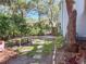 Charming backyard with a wooden bench, mature trees, brick patio, and a stone pathway at 2306 63Rd W St # 40, Bradenton, FL 34209
